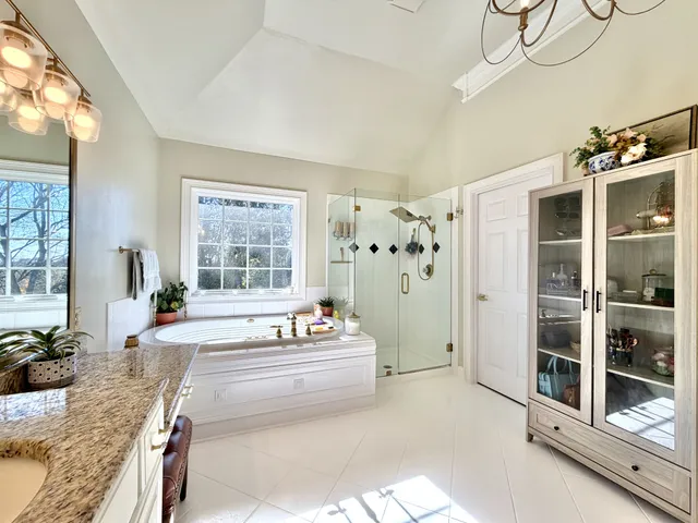 a spacious bathroom with a granite countertop tub sink and mirror