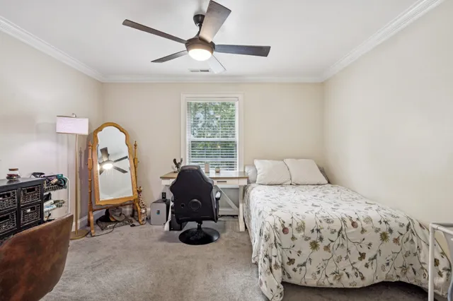 a bedroom with a bed large window and couch