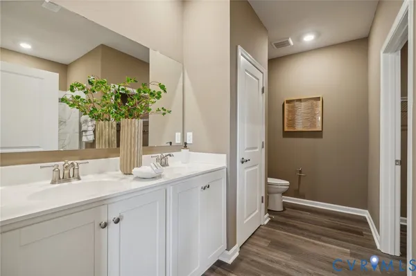 a bathroom with a granite countertop sink a toilet and a mirror