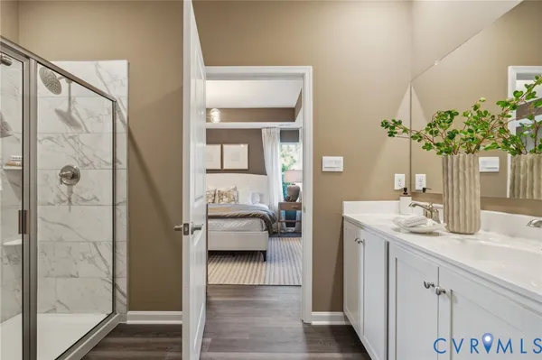 a en suite bathroom with a granite countertop sink and a mirror
