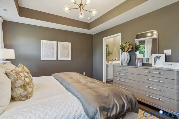 a bedroom with a large bed and a mirror on dresser