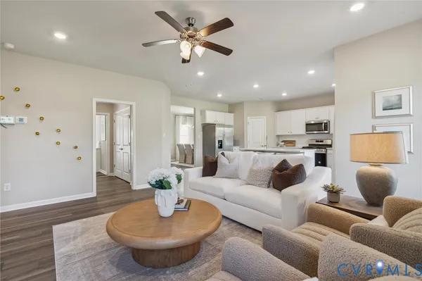 a living room with furniture and a view of kitchen