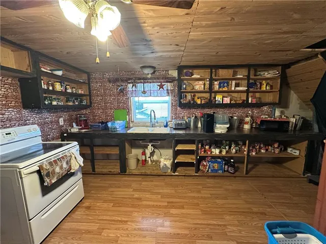 a kitchen with stainless steel appliances wooden floor and refrigerator