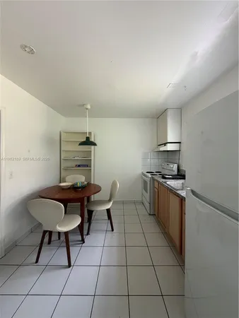 a kitchen with stainless steel appliances kitchen island granite countertop a sink and a refrigerator