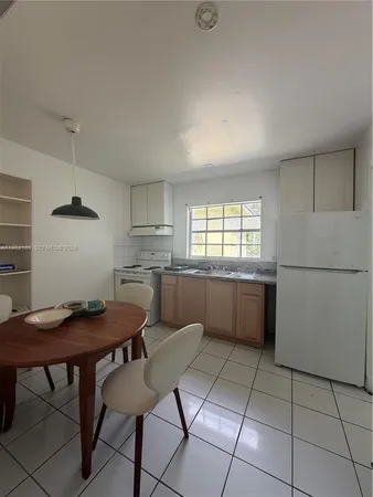 a kitchen with a table chairs and a refrigerator