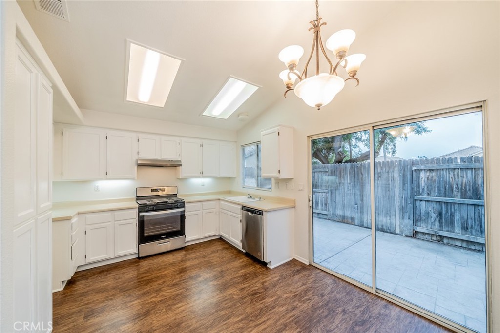 635 Laxford Road San Jacinto, CA 92583 - Photo 15 of 37 a kitchen with stainless steel appliances granite countertop a stove a sink and white cabinets with wooden floor