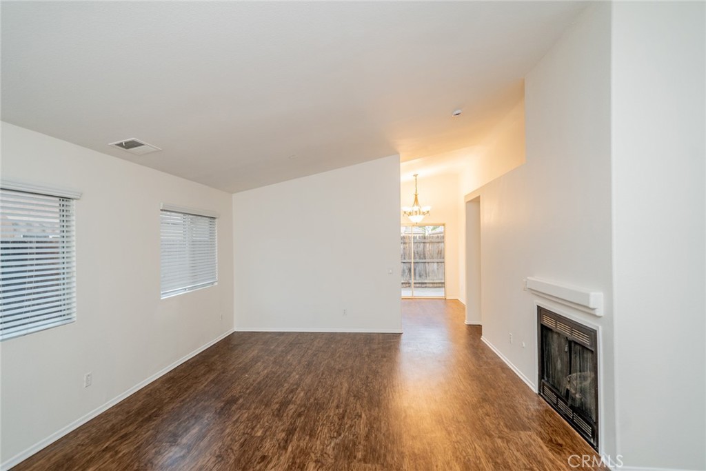 635 Laxford Road San Jacinto, CA 92583 - Photo 6 of 37 a view of empty room with wooden floor and fireplace