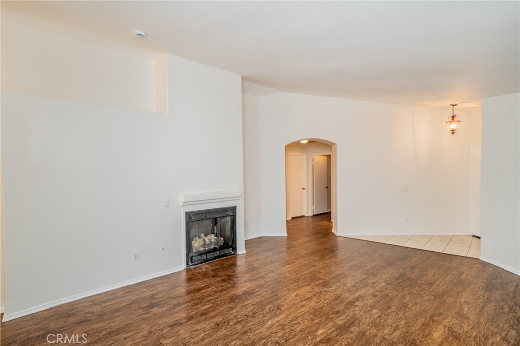 635 Laxford Road San Jacinto, CA 92583 - Photo 8 of 37 an empty room with wooden floor fireplace and staircase