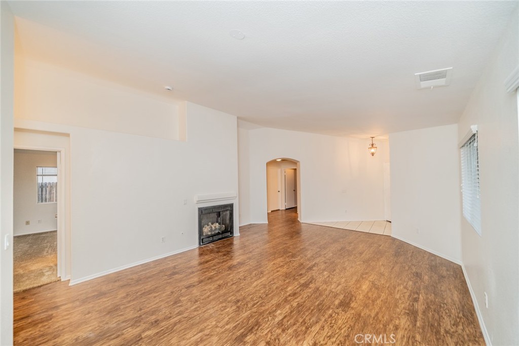 635 Laxford Road San Jacinto, CA 92583 - Photo 10 of 37 a view of an empty room with wooden floor and a fireplace