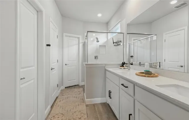 a spacious bathroom with a double vanity sink mirror and shower