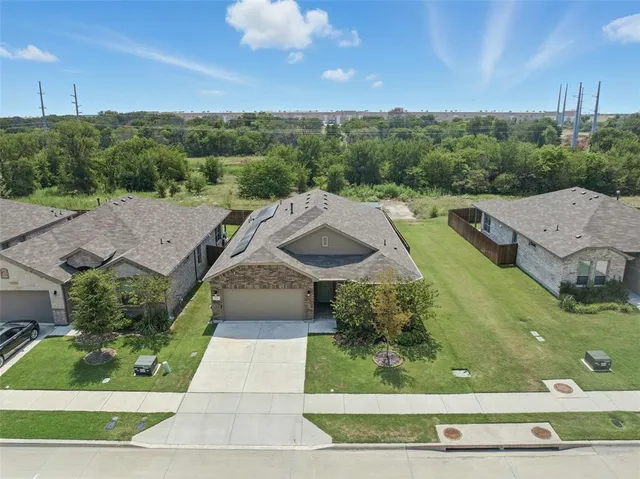 an aerial view of multiple houses with a yard