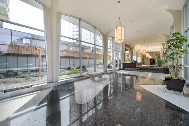 a very nice looking living room with a large window and dining table