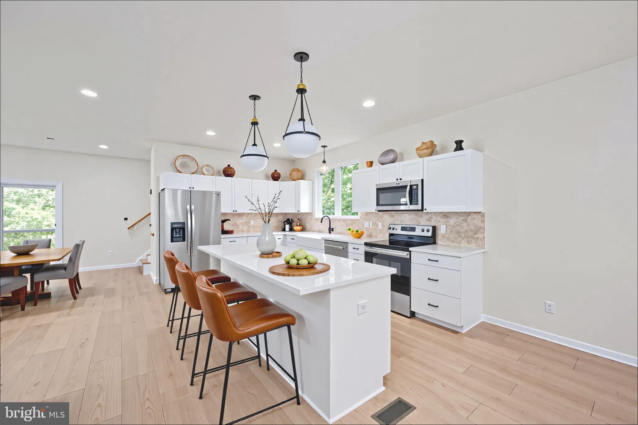 107 Saylers Creek Road Locust Grove, VA 22508 - Photo 13 of 78 a kitchen with stainless steel appliances kitchen island granite countertop a stove a sink a dining table and chairs with wooden floor