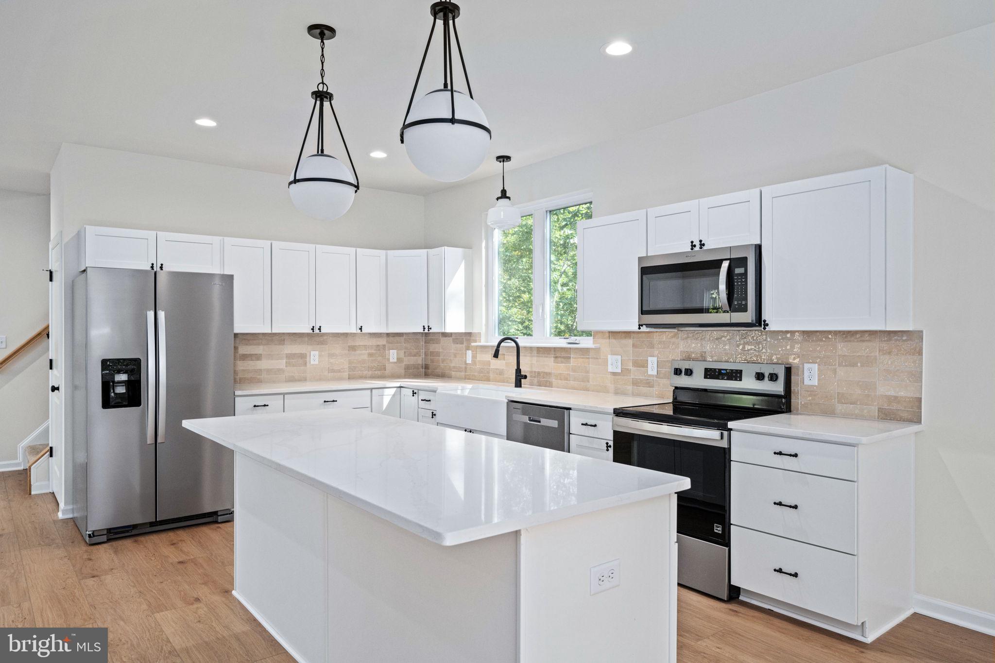107 Saylers Creek Road Locust Grove, VA 22508 - Photo 15 of 78 a kitchen with white cabinets and stainless steel appliances