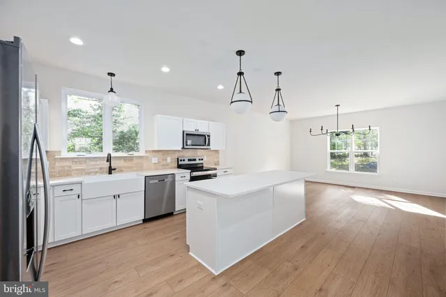 a view of a hallway with wooden floor and entryway