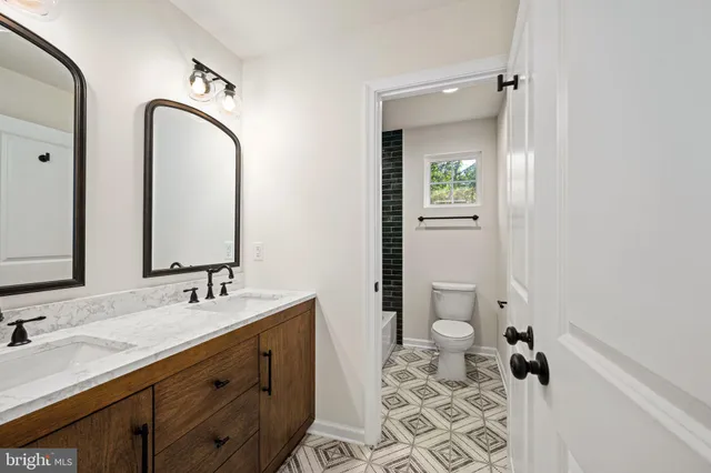 a view of a brick house next to a yard with big trees