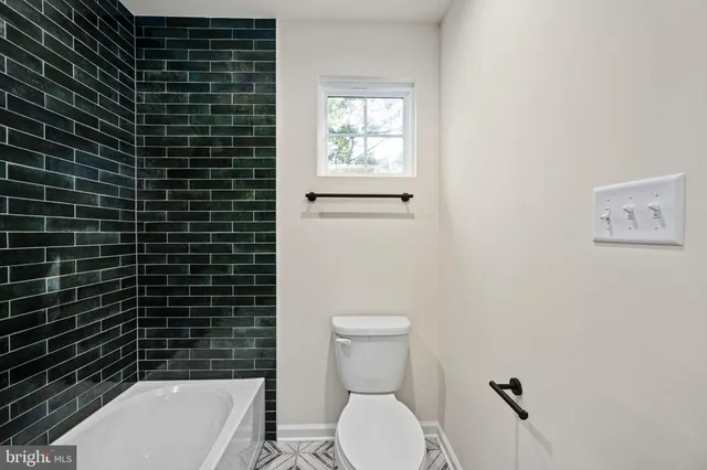 a view of a brick house next to a yard with big trees