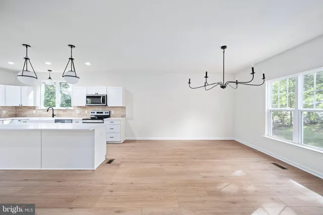 an empty room with wooden floor and outdoor space
