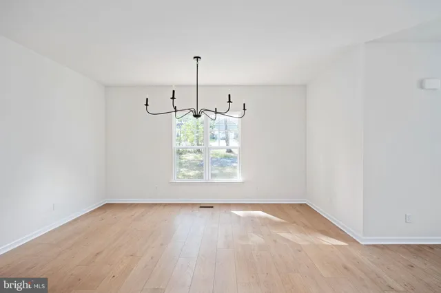 a kitchen with stainless steel appliances kitchen island granite countertop a stove a sink a dining table and chairs with wooden floor