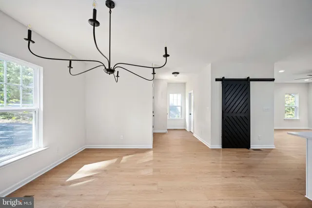 a kitchen with stainless steel appliances kitchen island wooden floors stove and white cabinets