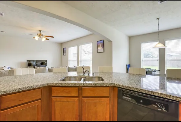 a kitchen with granite countertop a sink stainless steel appliances and a counter space