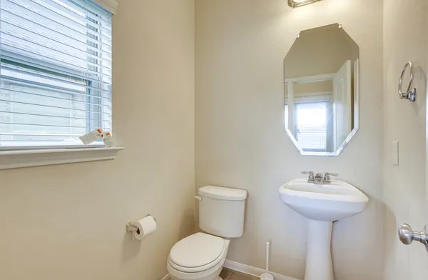 a bathroom with a toilet sink and mirror