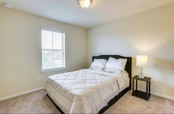 a bedroom with a bed and a window