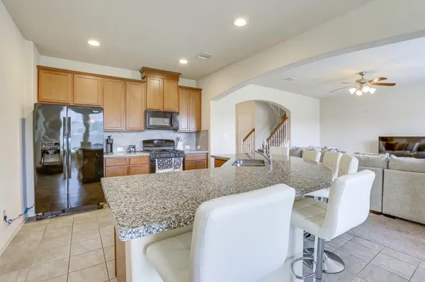 a living room with furniture a counter space a sink and a kitchen view