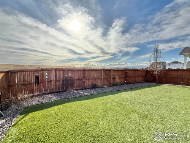 a view of a backyard with wooden fence