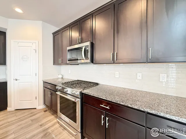 a kitchen with stainless steel appliances granite countertop a stove a sink and a microwave