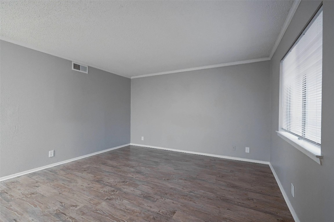 8100 North Mopac Expressway, Unit 1204 Austin, TX 78759 - Photo 11 of 24 Unfurnished room with dark wood finished floors, a textured ceiling, and crown molding