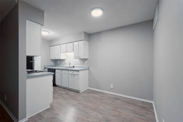 a kitchen with a sink a stove and cabinets