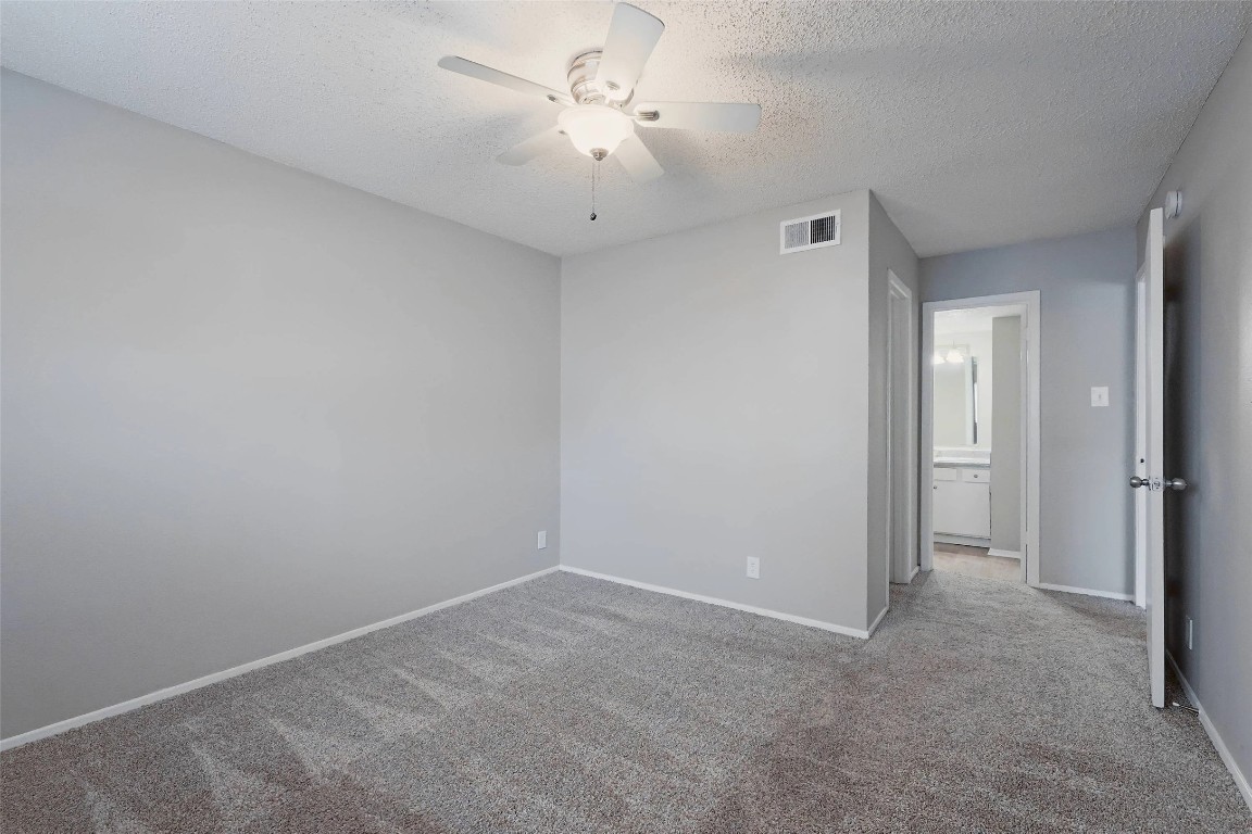 8100 North Mopac Expressway, Unit 1204 Austin, TX 78759 - Photo 16 of 24 Unfurnished bedroom with a textured ceiling, carpet flooring, a ceiling fan, and connected bathroom