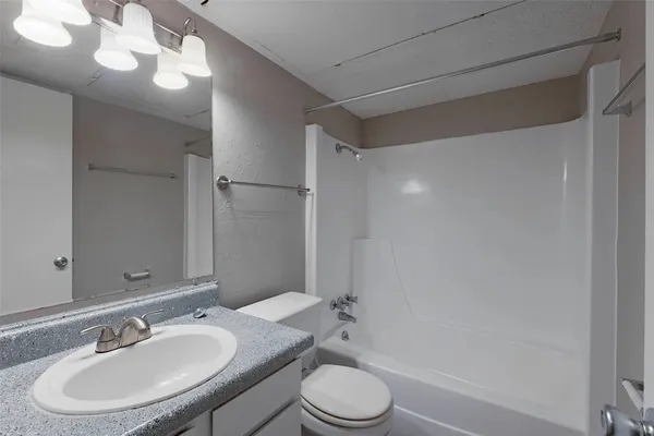 a bathroom with a sink toilet a mirror and shower