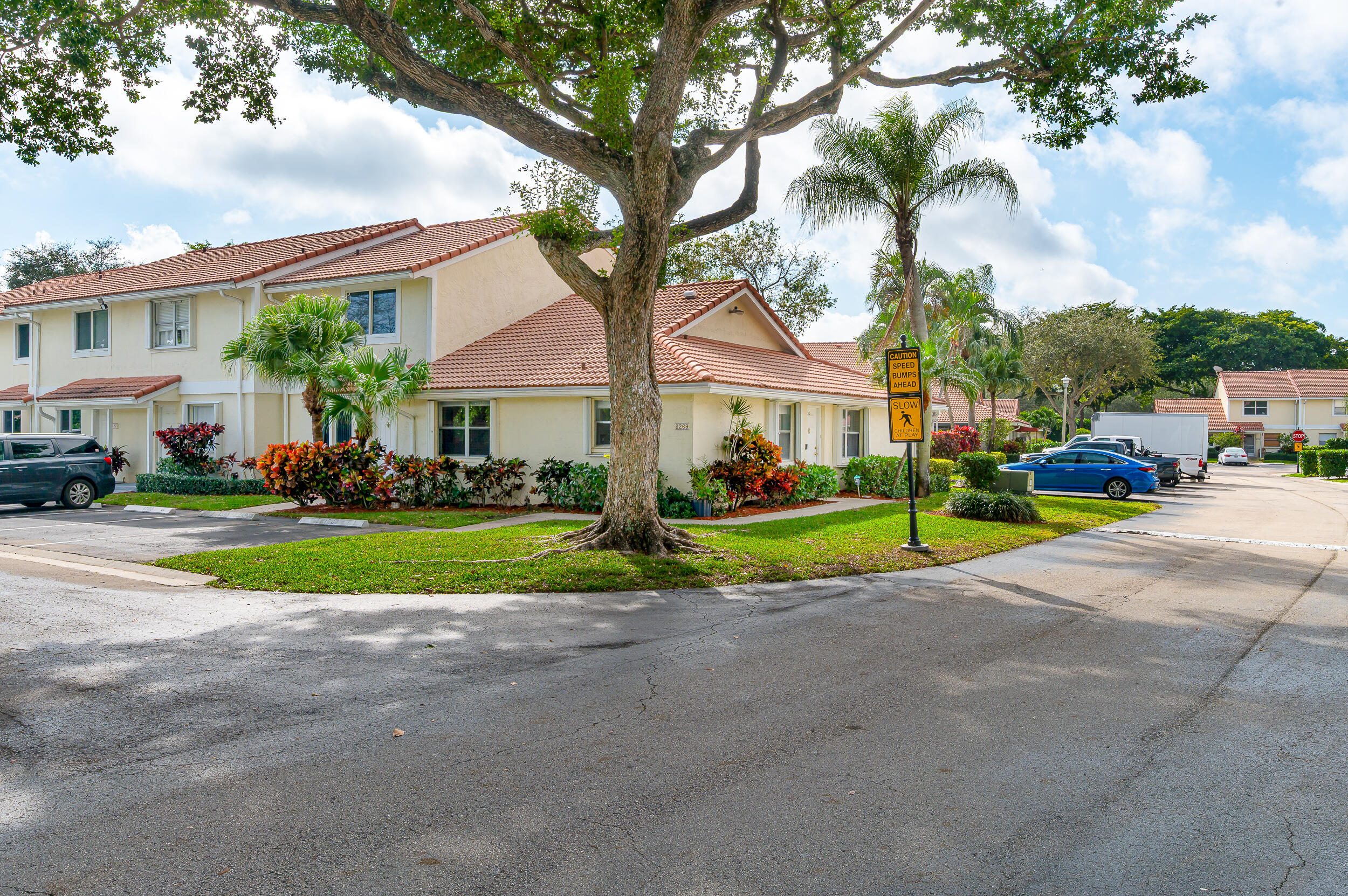 6269 Walk Circle Boca Raton, FL 33433 - Photo 2 of 27 a view of yellow house with a big yard and palm trees