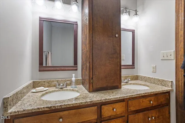 a bathroom with a granite countertop sink and a mirror