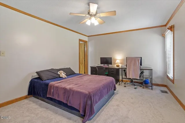 a bedroom with a bed desk and a window