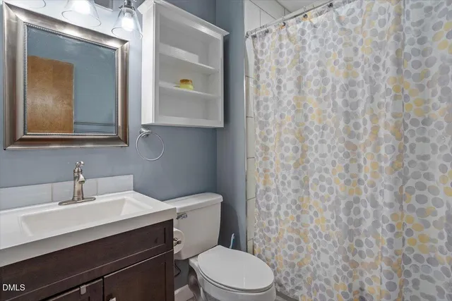 a bathroom with a toilet a sink and mirror