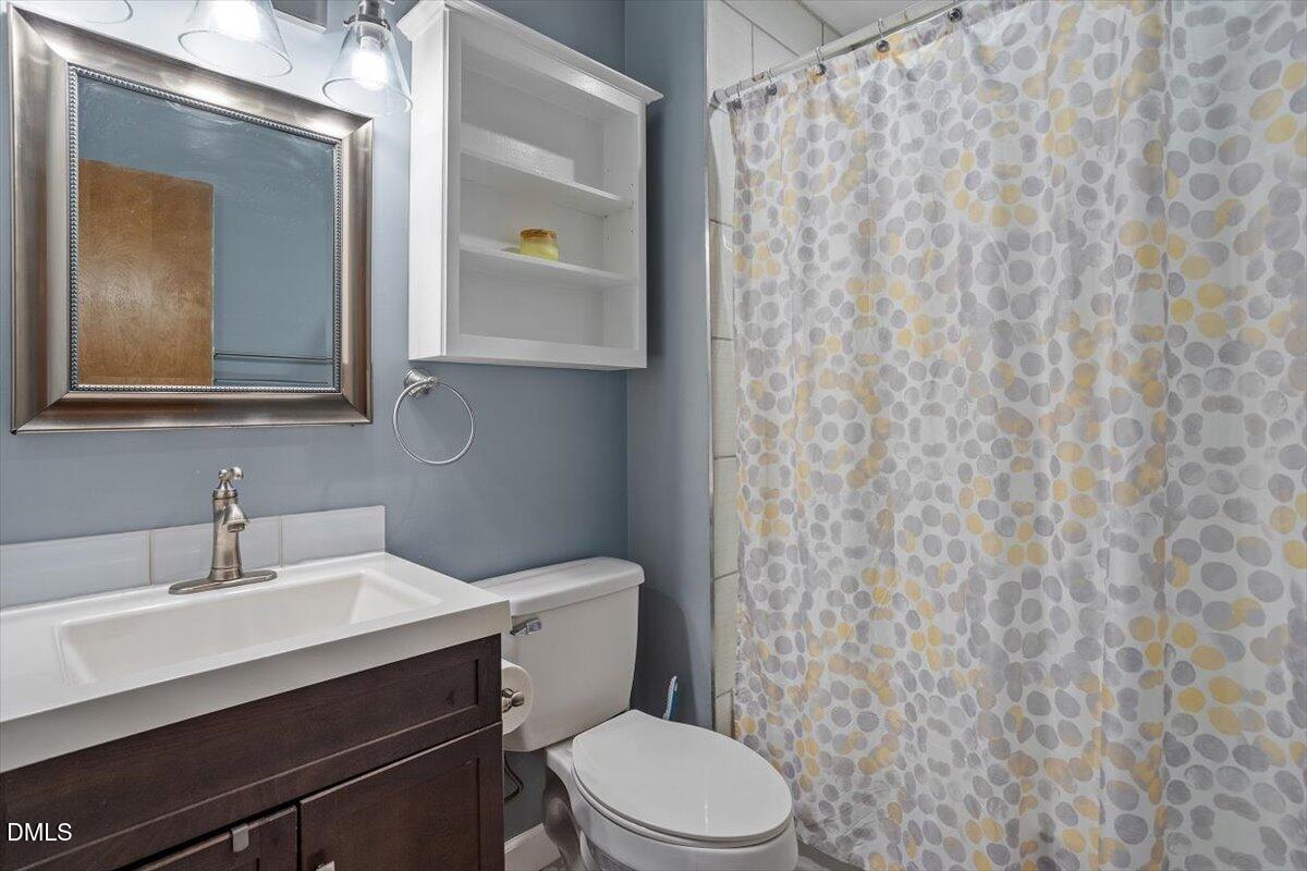 9966 US Highway 421 South Erwin, NC 28339 - Photo 29 of 34 a bathroom with a toilet a sink and mirror