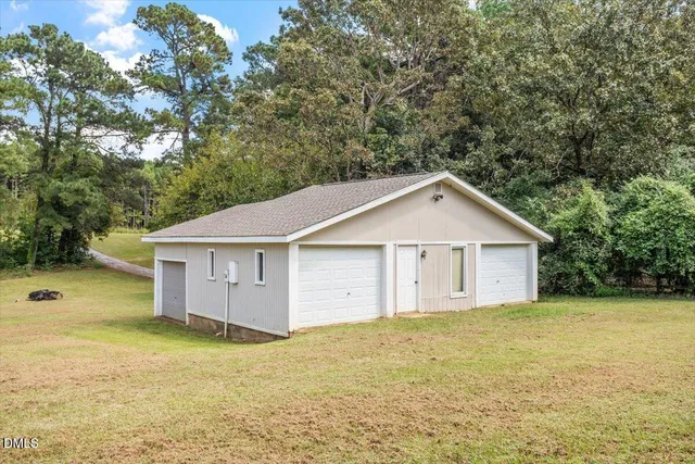 a view of a house with a yard and large trees