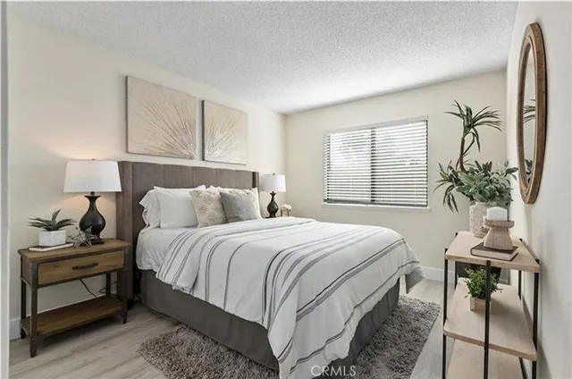 a bedroom with a bed and a potted plant