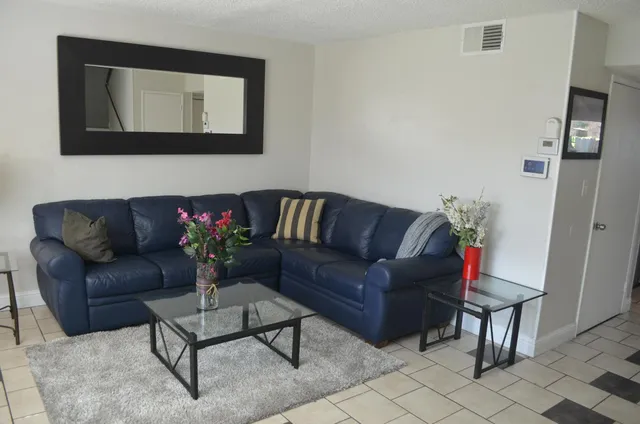 a living room with furniture and a potted plant