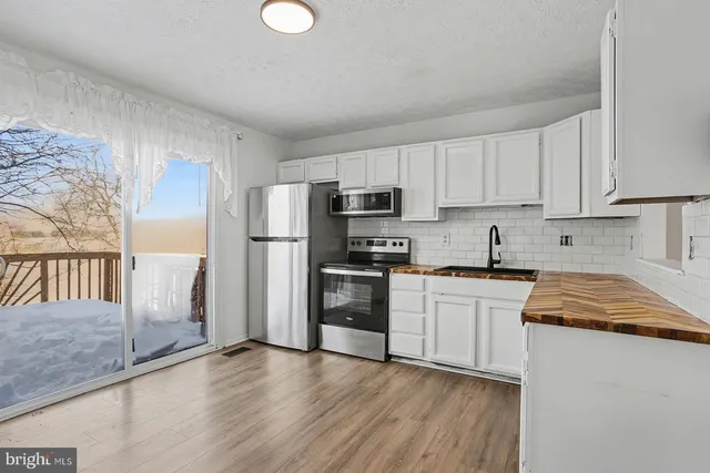 a kitchen with granite countertop white cabinets and white appliances
