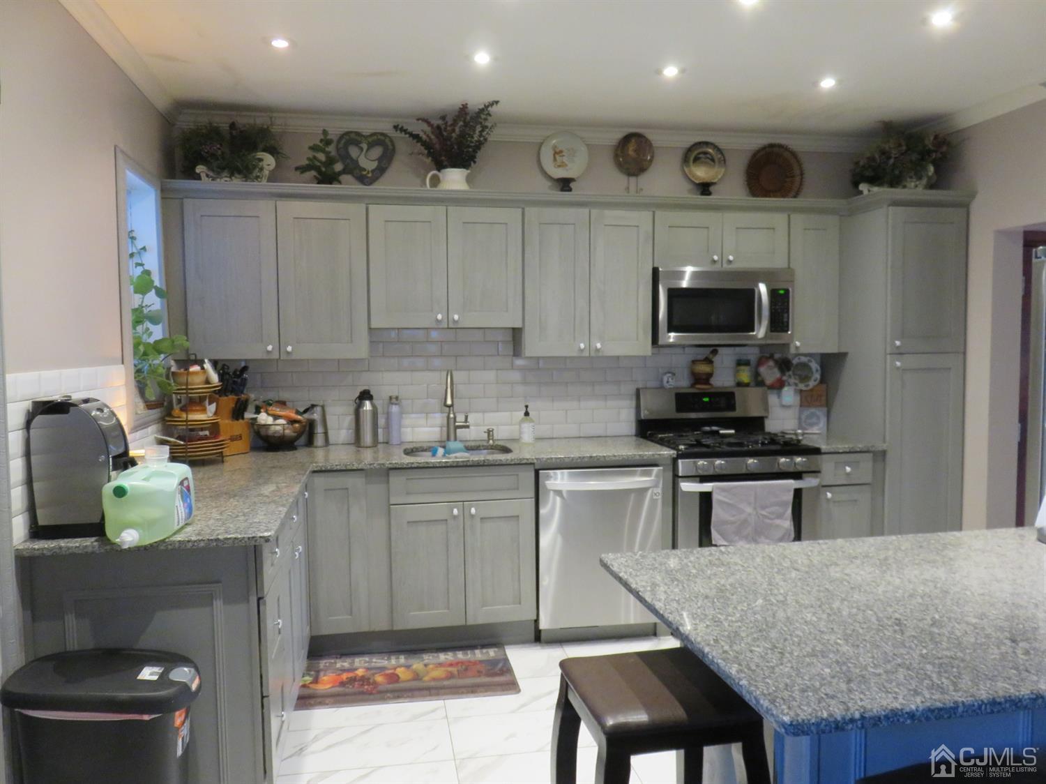 268 Rector Street Perth Amboy, NJ 08861 - Photo 4 of 13 a kitchen with kitchen island granite countertop a stove top oven a sink a table and chairs
