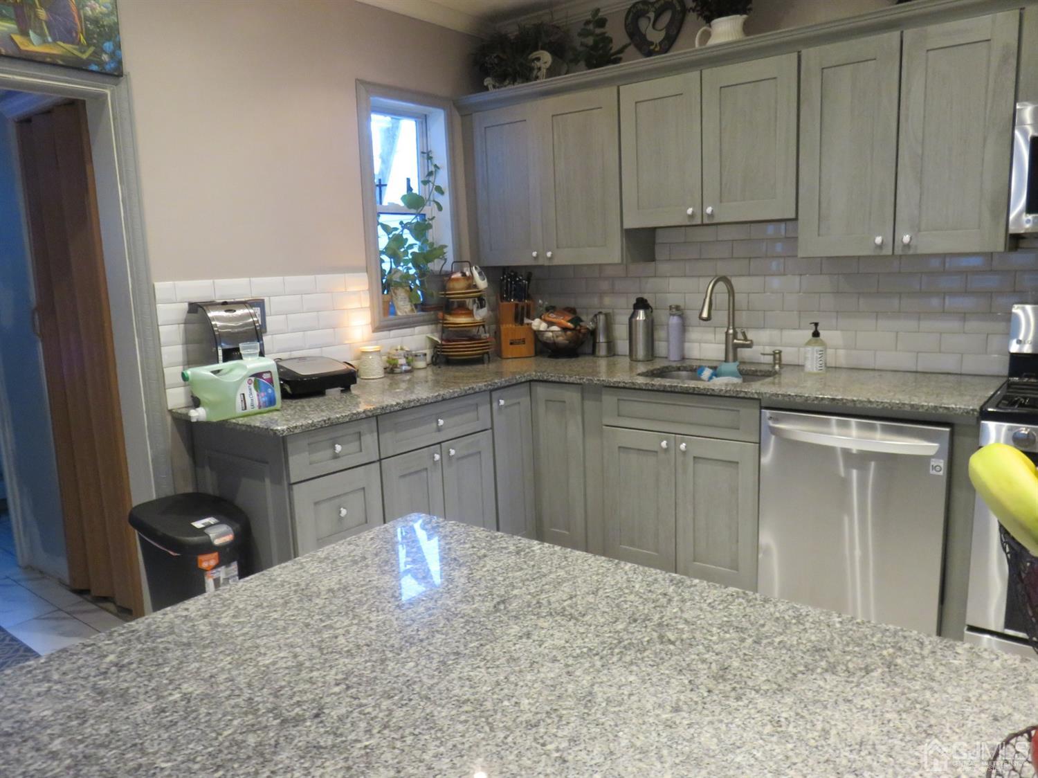 268 Rector Street Perth Amboy, NJ 08861 - Photo 5 of 13 a kitchen with kitchen island granite countertop a sink cabinets and window