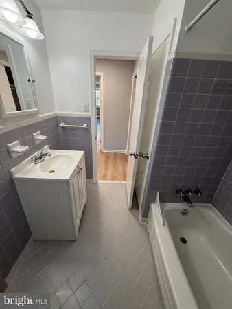 a bathroom with a tub a sink a mirror and shower