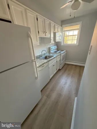 a kitchen with appliances a sink and cabinets