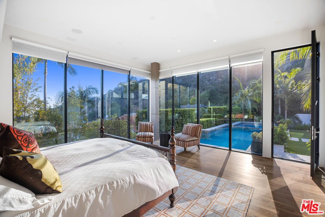 1717 Rising Glen Road Los Angeles, CA 90069 - Photo 20 of 30 a bed sitting in a bedroom next to a large window