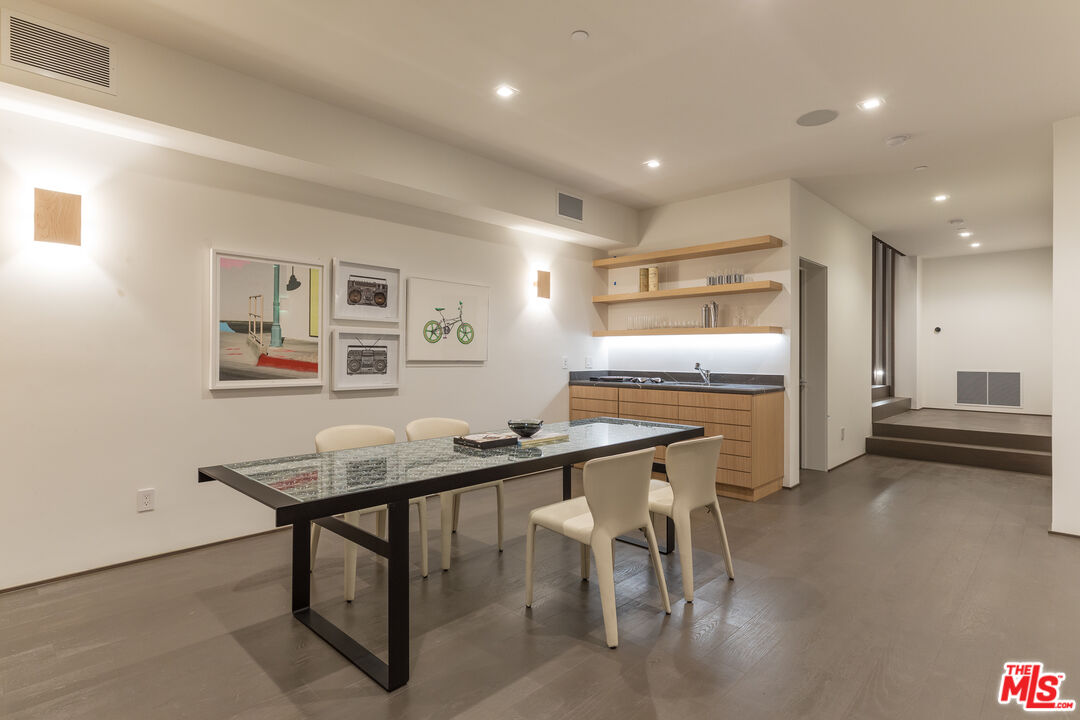 1717 Rising Glen Road Los Angeles, CA 90069 - Photo 29 of 30 a kitchen with stainless steel appliances kitchen island granite countertop a table and chairs in it