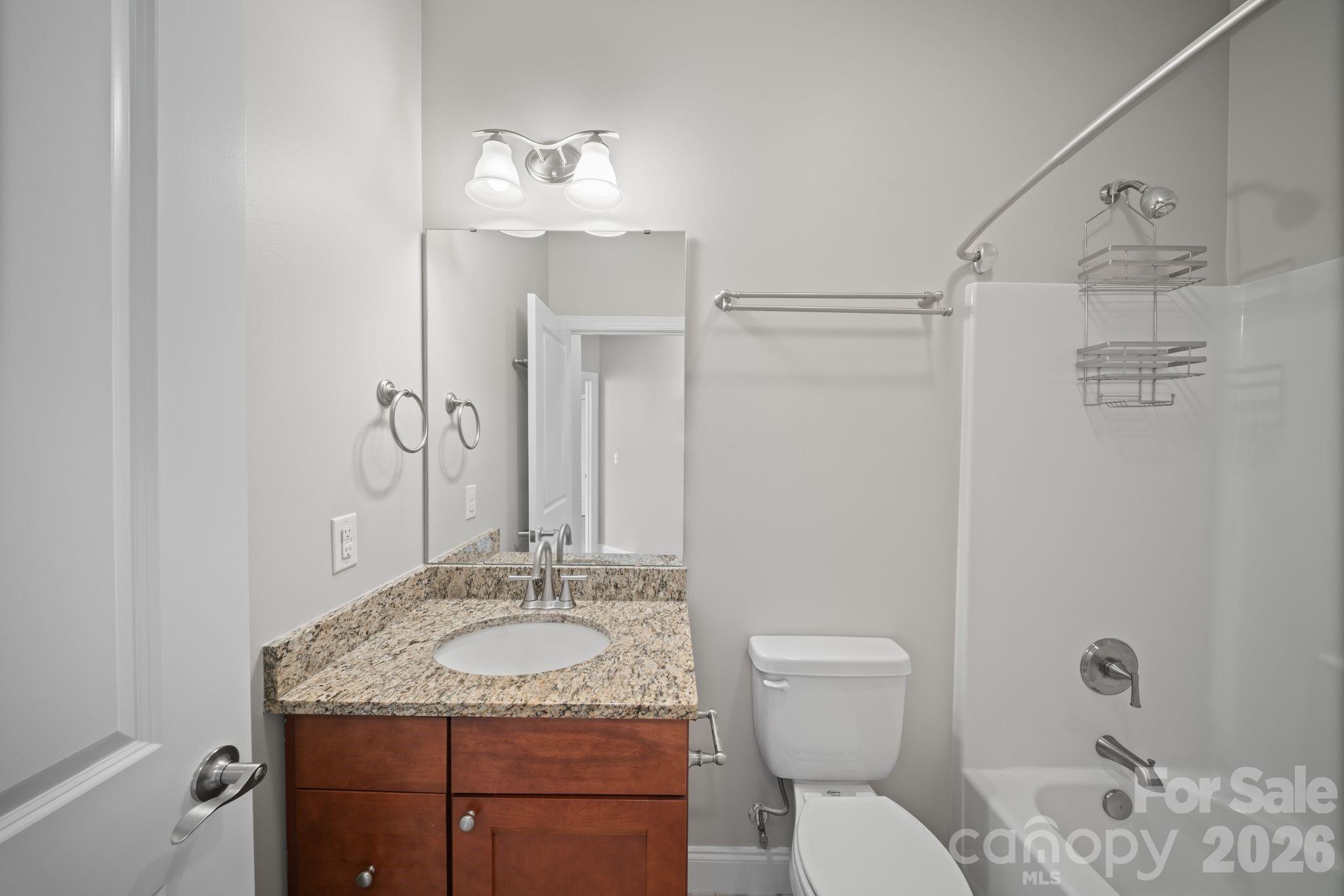 14 Rose Creek Road Leicester, NC 28748 - Photo 21 of 42 a bathroom with a granite countertop sink a toilet and a mirror